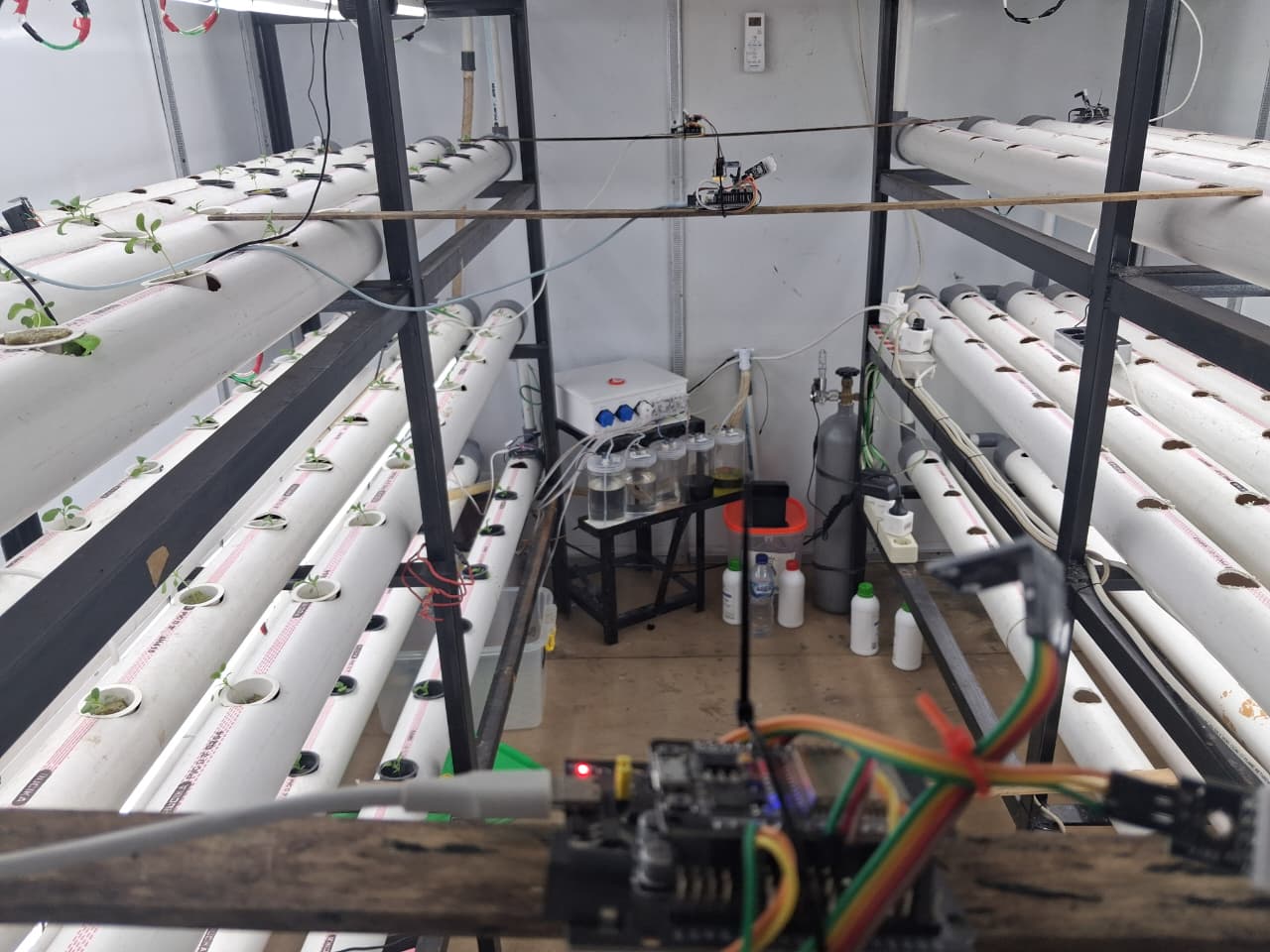 Interior kontainer indoor farming dengan rak hidroponik, sensor, dan perangkat aktuasi